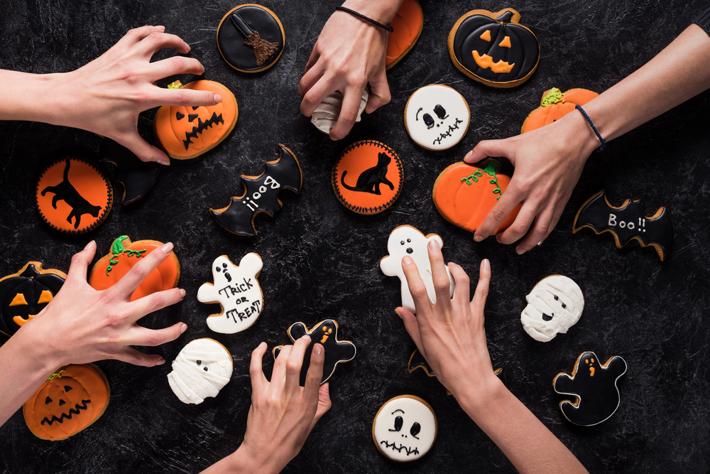 hands reaching for Halloween cookies