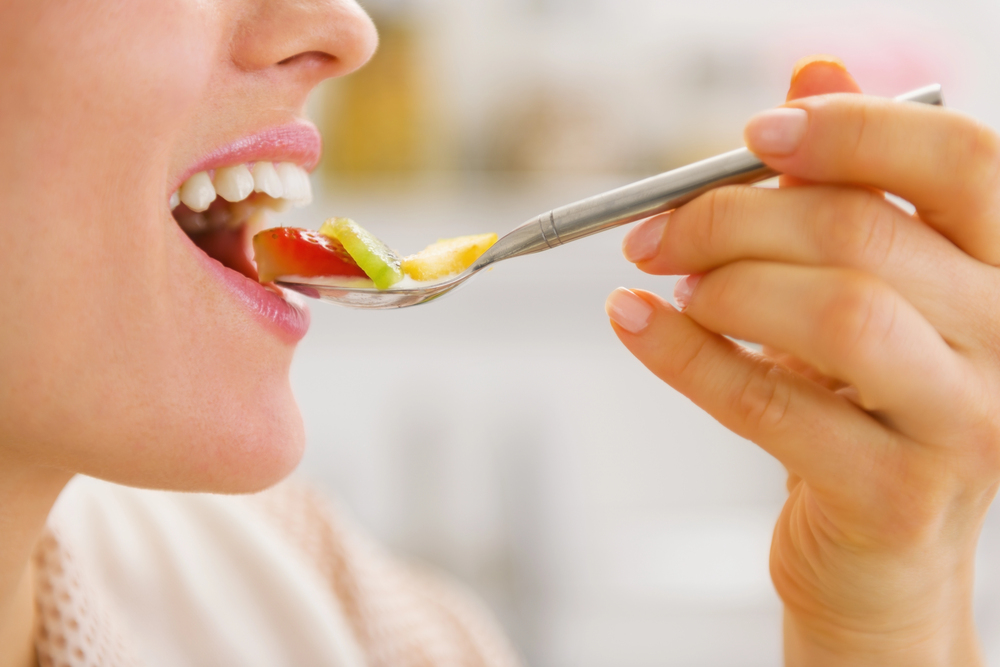 woman placing a spoonful of food in her mouth