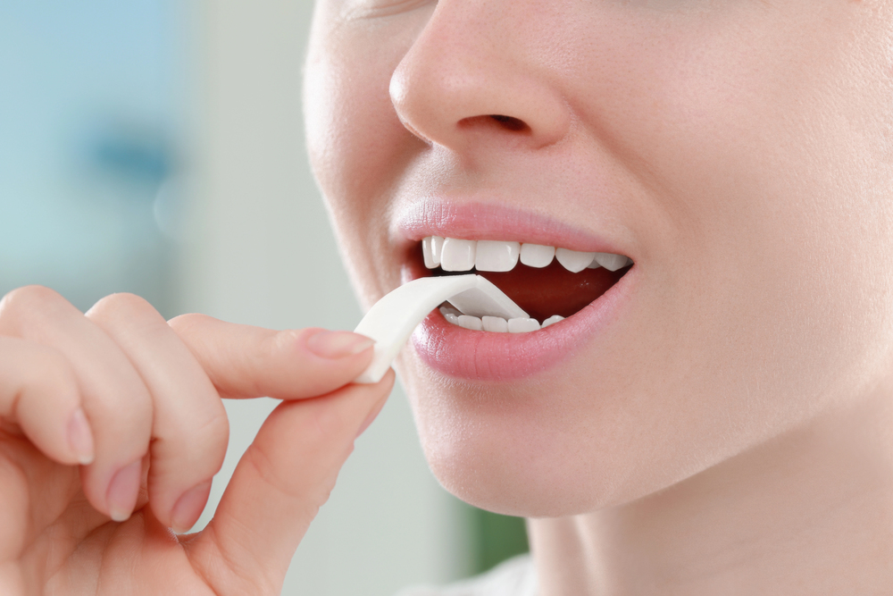 young woman placing gum in her mouth