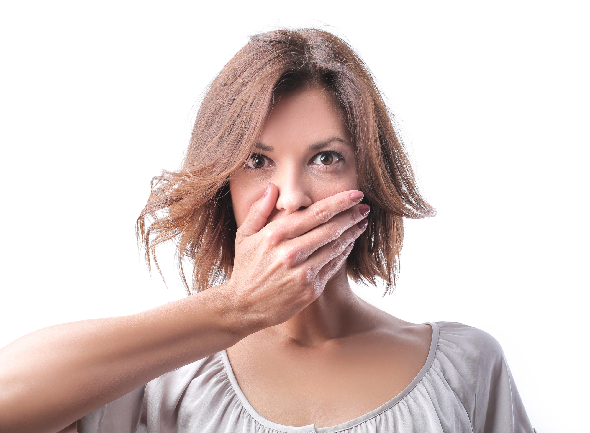 a white woman with short hard holds a hand over her mouth as if to say, 