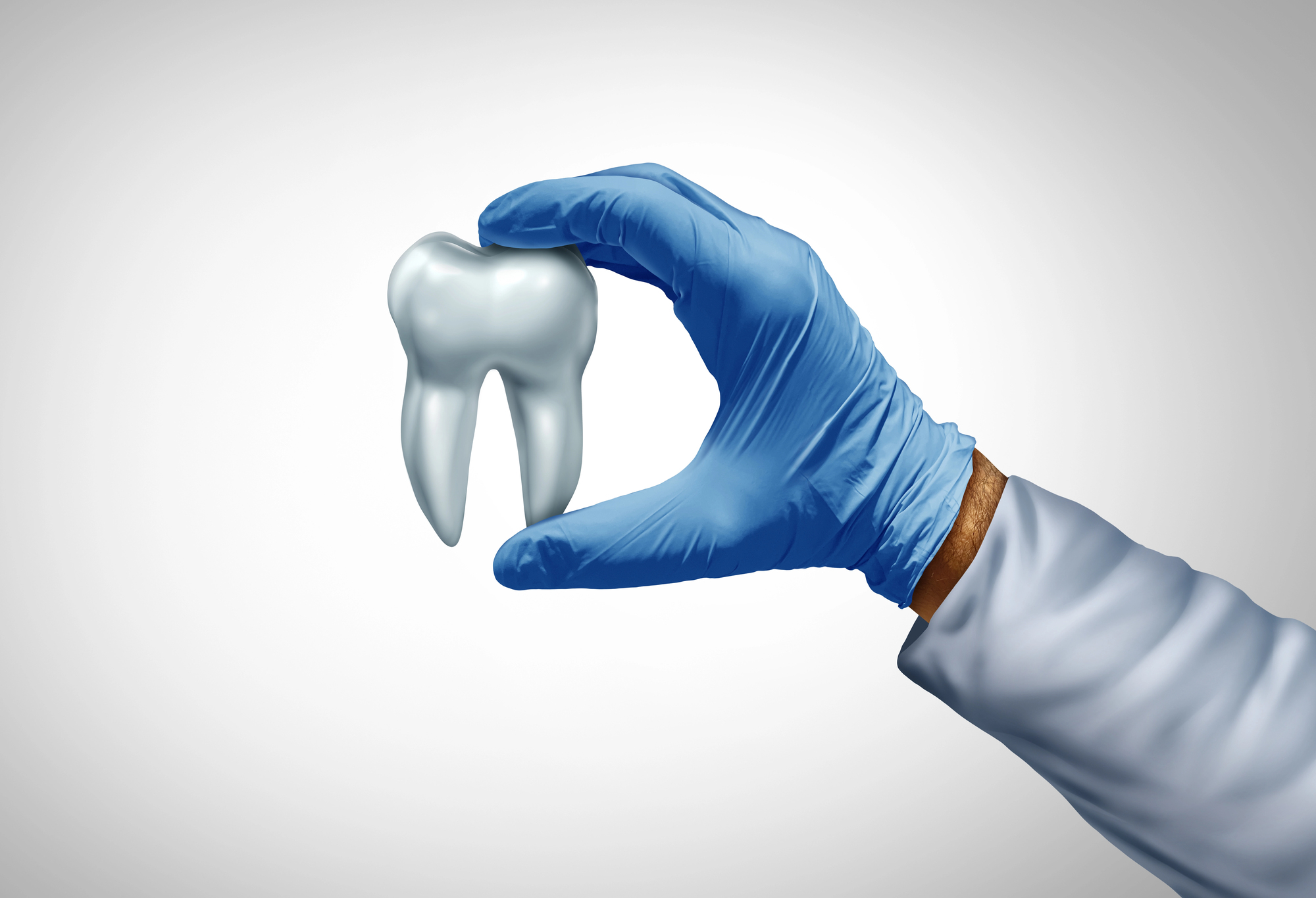The gloved hand of a Homewood dentist holds a model of a tooth against a white background