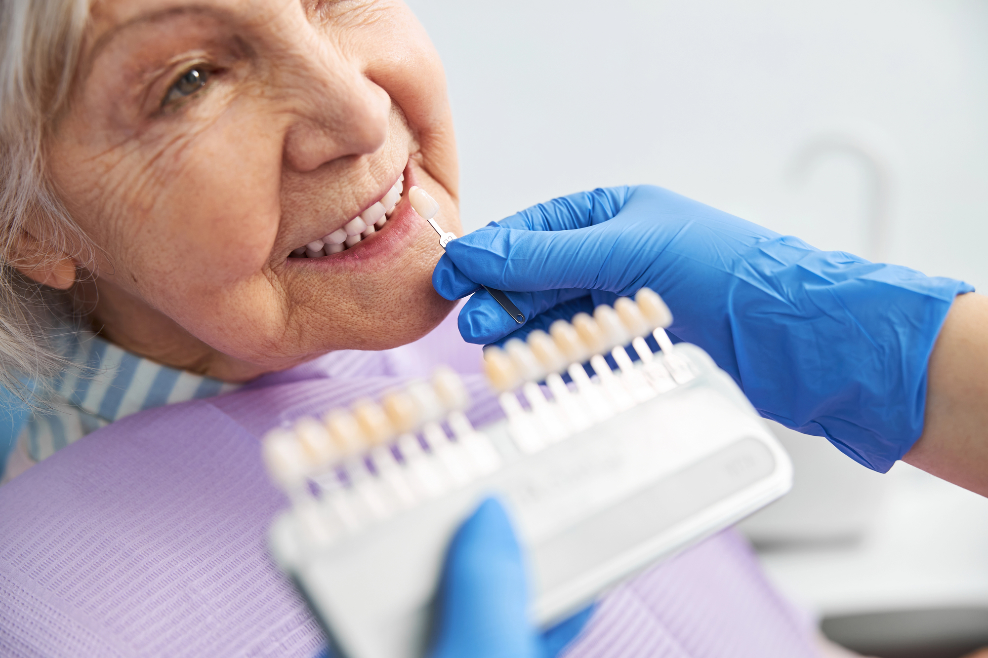 Depositphotos_457427940_L senior dental patient with cosmetic shading tool for smile makeover