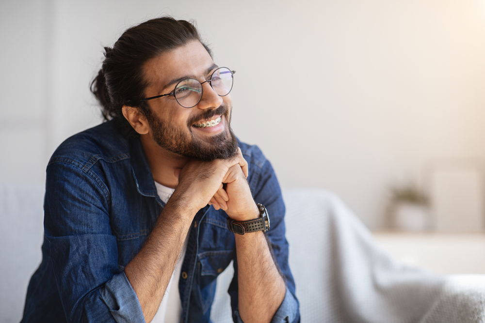 PortraitOfSmilingIndianManWithEyeglassesAndBracesIn